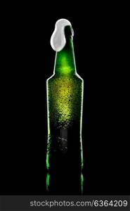 beer bottle opened with resultant beer and foam on black background with reflection