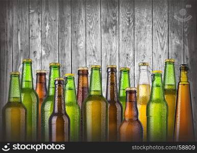 beer bottles on wooden background with drops