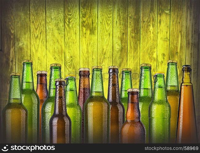 beer bottles on wooden background with drops