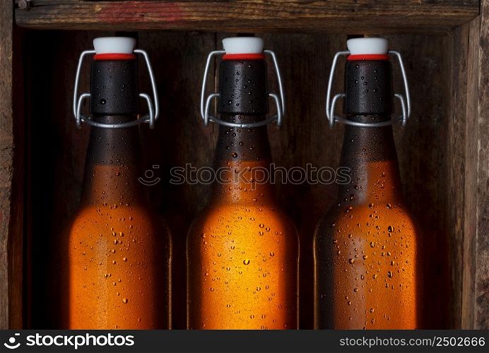 Beer bottles with vintage swing tops in old wooden crate still life