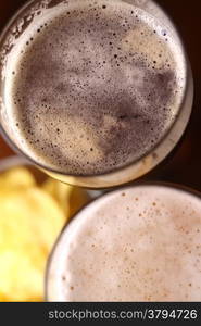 Beer glass with some snacks in the background