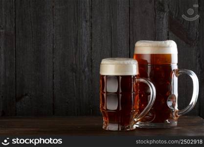 Beer glasses on table, dark wooden background with copy space