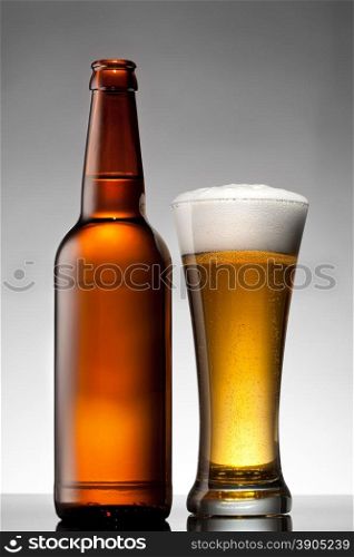 Beer in glass and bottle on white