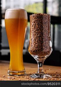 Beer in glass and wheat in glass on wooden table. glass of beer and wheat in glass on wooden table