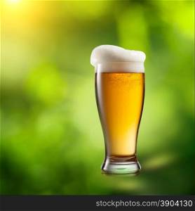Beer in glass on natural green background