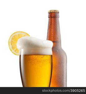 Beer in glass with lemon and bottle isolated on white