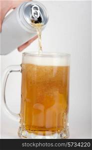 beer is pouring into glass on white background