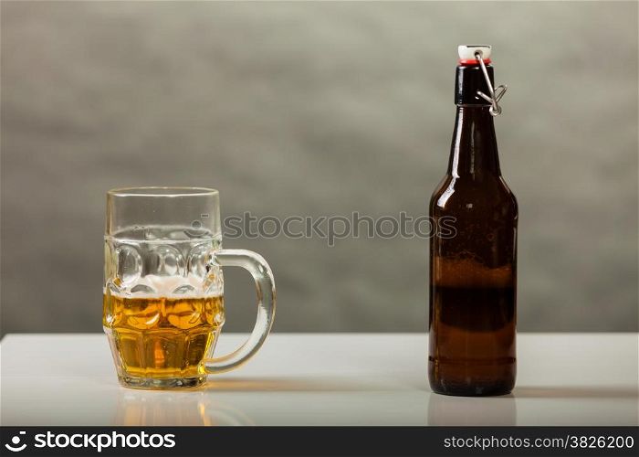 beer mug and bottle on table gray background