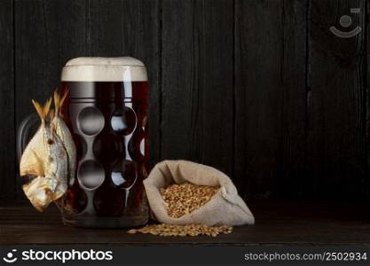 Beer mug with smoked salty fish snack and bag of barley