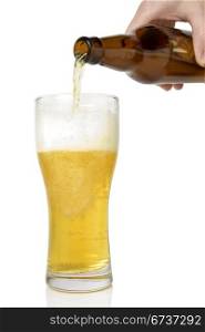 Beer pouring from bottle into glass on white background