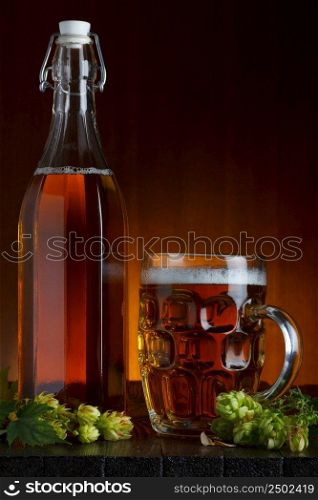 Beer still-life with fresh green hop on rustic wooden table