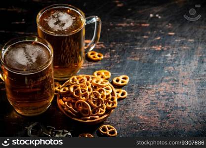 Beer with salty pretzels. On rustic background.. Beer with salty pretzels. 
