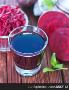 beet juice in glass and on a table
