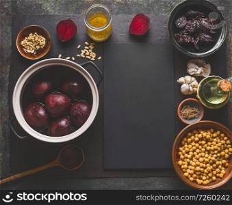 Beet root salad preparation with pine nuts, chickpeas and prunes on dark background, top view with copy space for your design. Healthy clean, low calories food and diet and detox eating concept