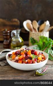Beetroot or beet salad with boiled vegetables on wooden rustic table closeup