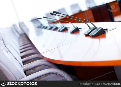 before a conference, the microphones in front of empty chairs.