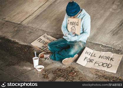 Beggars sitting under the bridge with a sign, please home.