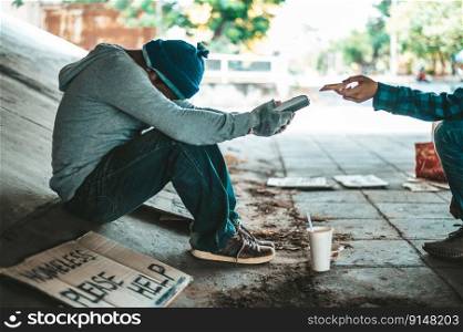Beggars sitting under the overpass with a credit card and credit card swipe machine.