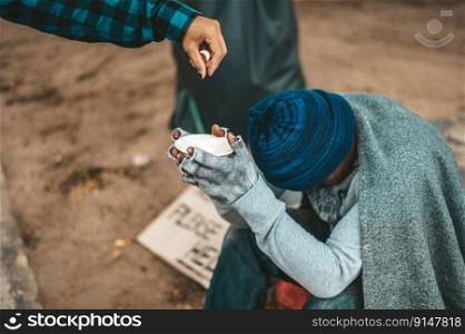 Beggars wrapped in cloth and then put on a hat and sat down beside the street and someone gave money.
