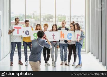Behide the scene of photographer taking photo group of asian and Multiethnic Business people with casual suit doing with Literal translation and showing the together word in the modern workplace