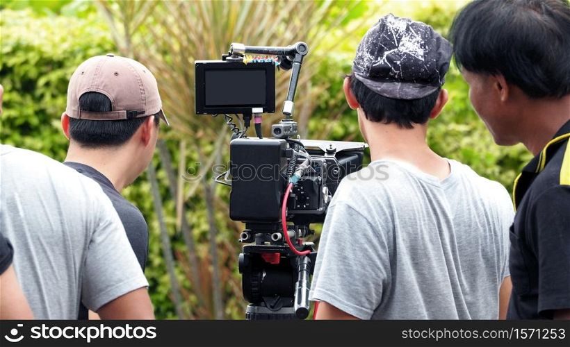 Behind the scenes of movie shooting or video production and film crew team with camera equipment at outdoor location.