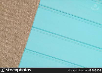 Beige and white towel over the surface of a wooden table.