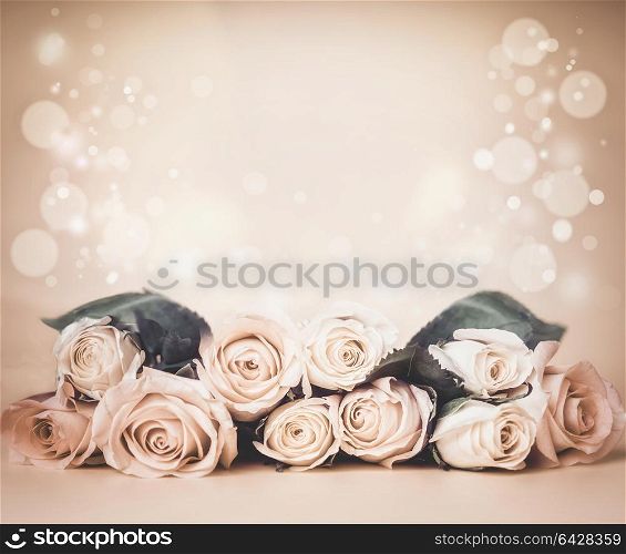 Beige floral background with roses on tables and bokeh. Holidays greeting or wedding concept