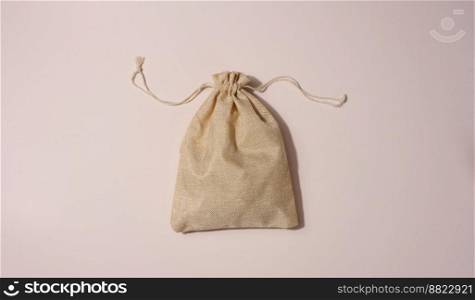 Beige full canvas bag on a beige background, top view