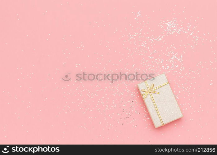 Beige gift box with bow in corner on pink pastel background in minimal style. Top view Copy space Mockup.. Beige gift box with bow in corner on pink pastel background in minimal style. Top view Copy space Mockup