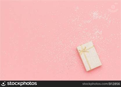 Beige gift box with bow in corner on pink pastel background in minimal style. Top view Copy space Mockup.. Beige gift box with bow in corner on pink pastel background in minimal style. Top view Copy space Mockup