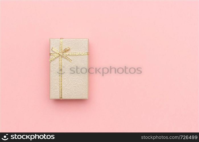 Beige gift box with bow on pink pastel background in minimal style. Top view Copy space Mockup.. Beige gift box with bow on pink pastel background in minimal style. Top view Copy space Mockup
