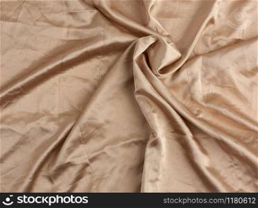 beige satin textile fabric, piece of canvas for sewing curtains and things, full frame. Crumpled textile satin, great design for any purposes.