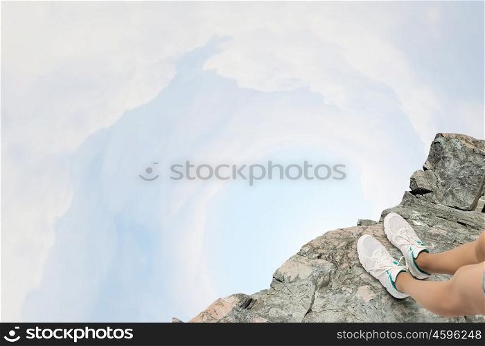 Being on verge. Close up of woman legs standing on the edge of rock