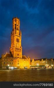 Belfry tower famous tourist destination and Grote markt square in Bruges, Belgium on dusk in twilight. Belfry tower and Grote markt square in Bruges, Belgium on dusk in twilight