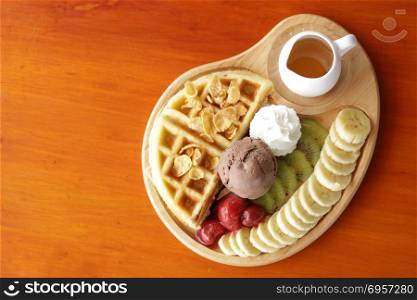 belgian waffles dessert, waffle and chocolate ice cream with fresh fruit and syrup. waffle and chocolate ice cream with fresh fruit and syrup