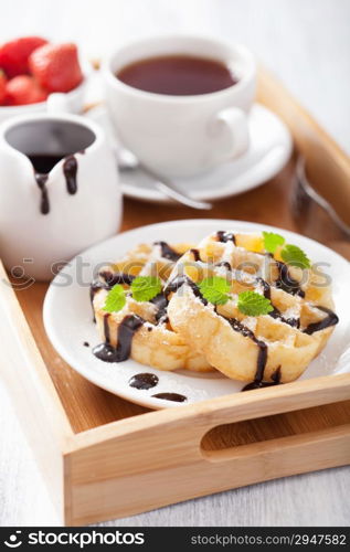 Belgian waffles with chocolate and powder sugar for breakfast