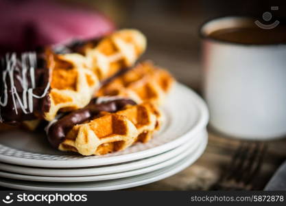 Belgian waffles with chocolate on rustic wooden background