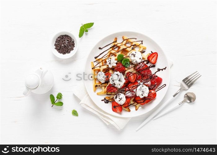Belgian waffles with fresh strawberry, chocolate topping and whipped cream