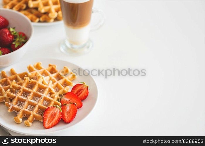 Belgian waffles with strawberry and coffee latte on white plate. Breakfast food concept. Copy space
