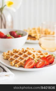 Belgian waffles with strawberry and powdered sugar on white plate. Breakfast food concept