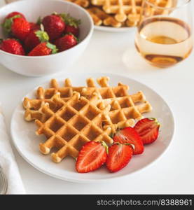 Belgian waffles with strawberry on white plate. Breakfast food concept