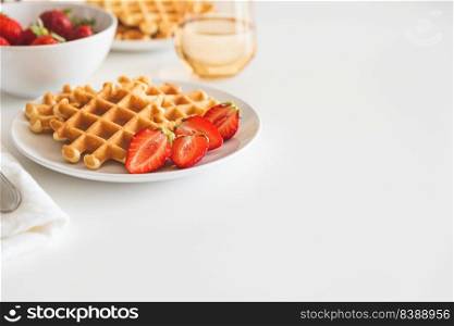 Belgian waffles with strawberry on white plate. Breakfast food concept. Copy space