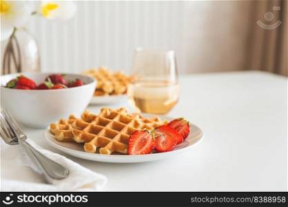Belgian waffles with strawberry on white plate. Breakfast food concept. Copy space