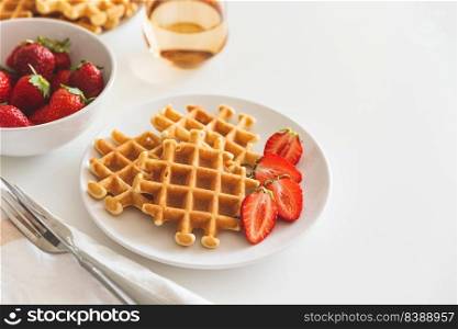 Belgian waffles with strawberry on white plate. Breakfast food concept. Copy space. Top view