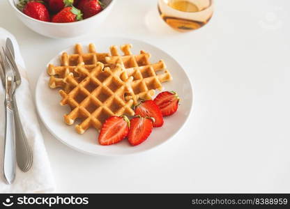 Belgian waffles with strawberry on white plate. Breakfast food concept. Copy space. Top view