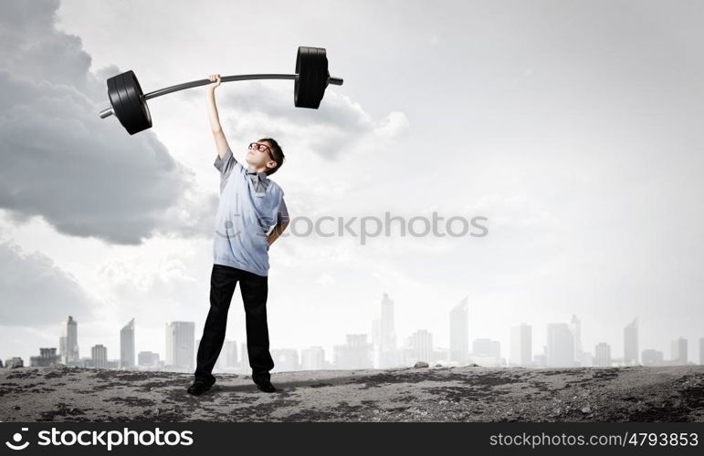 Believe in yourself. Cute boy of school age lifting barbell above head