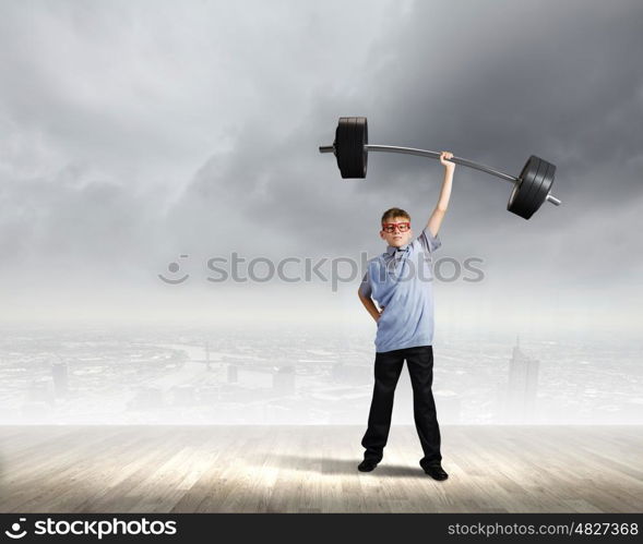 Believe in yourself. Cute boy of school age lifting barbell above head