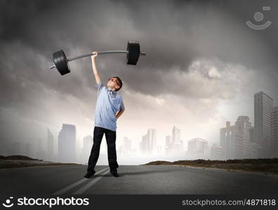 Believe in yourself. Cute boy of school age lifting barbell above head