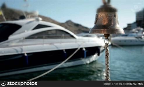 Bell in emergency on a background of yachts