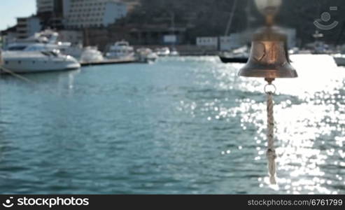 Bell in emergency on a background of yachts